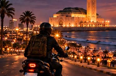 Motorbike rider on a lit Casablanca street at night with city lights behind